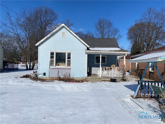 snow covered house featuring a porch