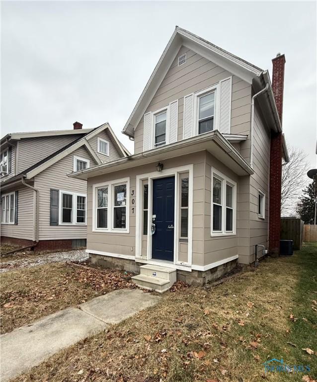 front of property with a front lawn and central AC unit