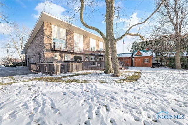 view of snow covered back of property