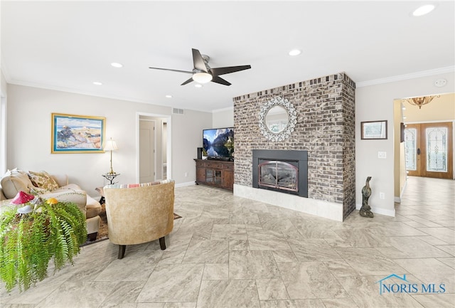 living room featuring ceiling fan, crown molding, french doors, and a fireplace