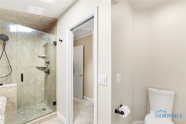 bathroom featuring crown molding, a shower with door, and toilet