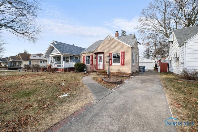 bungalow featuring a front lawn and a porch