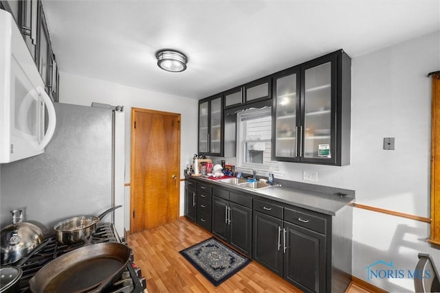 kitchen featuring light hardwood / wood-style floors, stainless steel fridge, and sink