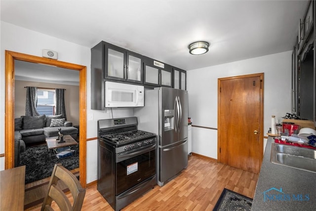 kitchen with sink, stainless steel appliances, and light hardwood / wood-style floors