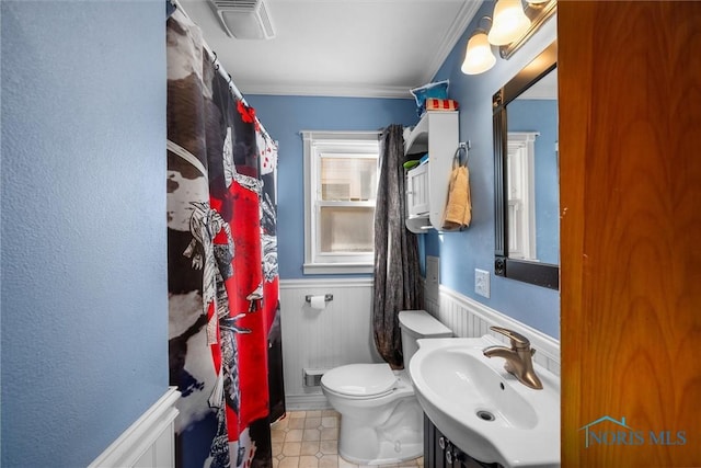 bathroom with toilet, sink, and crown molding