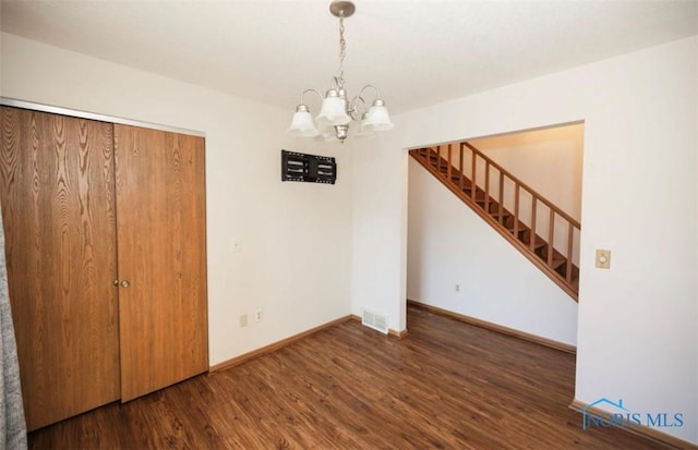 unfurnished dining area with dark hardwood / wood-style floors and a notable chandelier