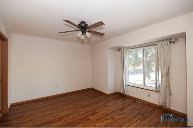 empty room with dark wood-type flooring and ceiling fan