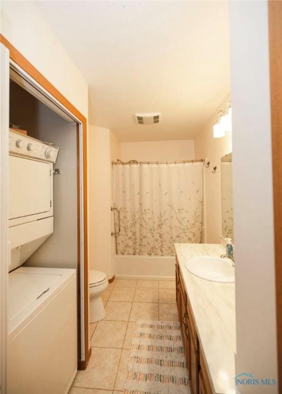 full bathroom featuring tile patterned floors, toilet, shower / tub combo, vanity, and stacked washing maching and dryer