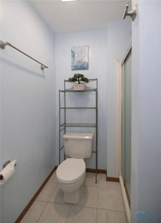 bathroom featuring an enclosed shower, tile patterned floors, and toilet