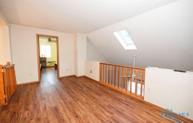 bonus room featuring dark wood-type flooring and lofted ceiling with skylight