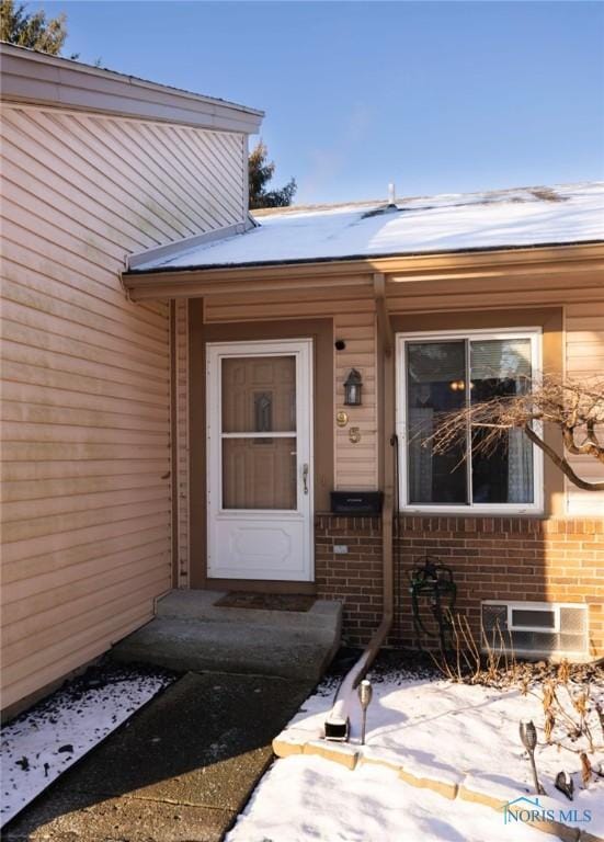 view of snow covered property entrance