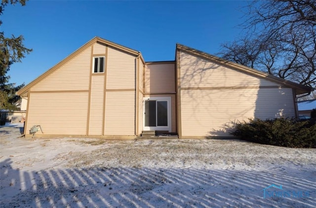 view of snow covered rear of property