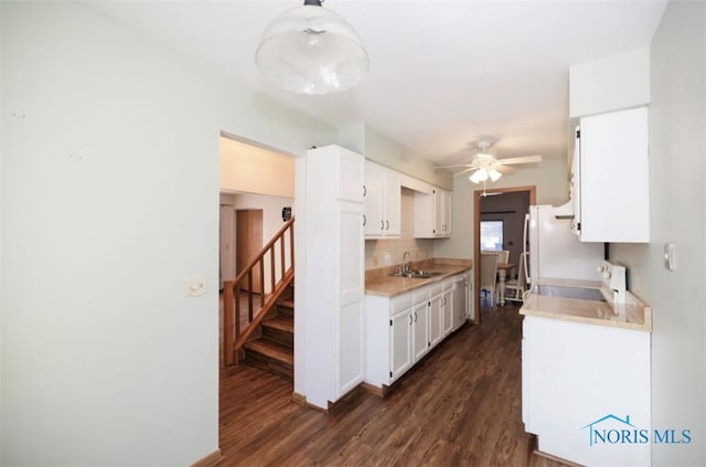 kitchen with sink, range, white cabinetry, backsplash, and dark hardwood / wood-style flooring