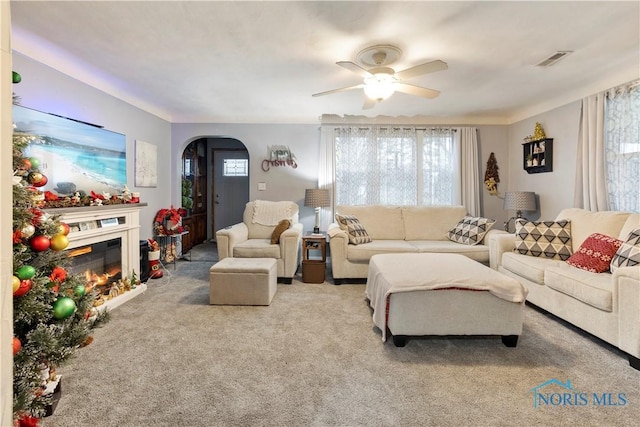 carpeted living room featuring ceiling fan and a healthy amount of sunlight