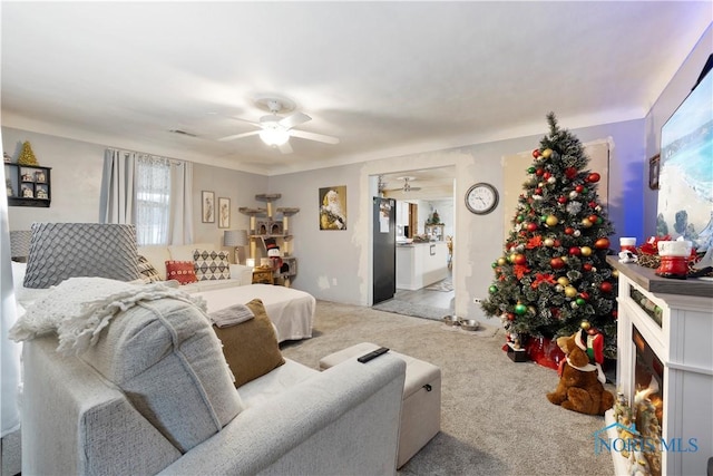 carpeted living room with ceiling fan