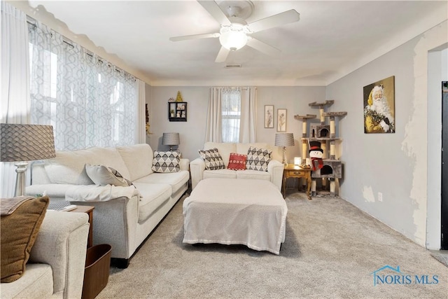 carpeted living room with ceiling fan