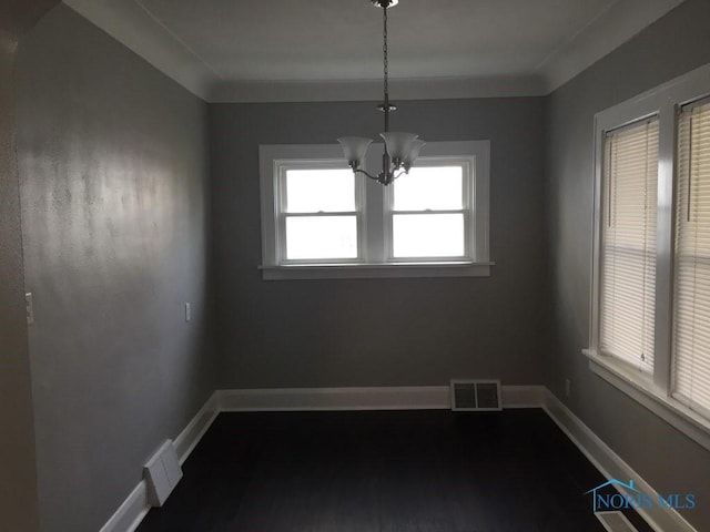 unfurnished dining area with crown molding and an inviting chandelier