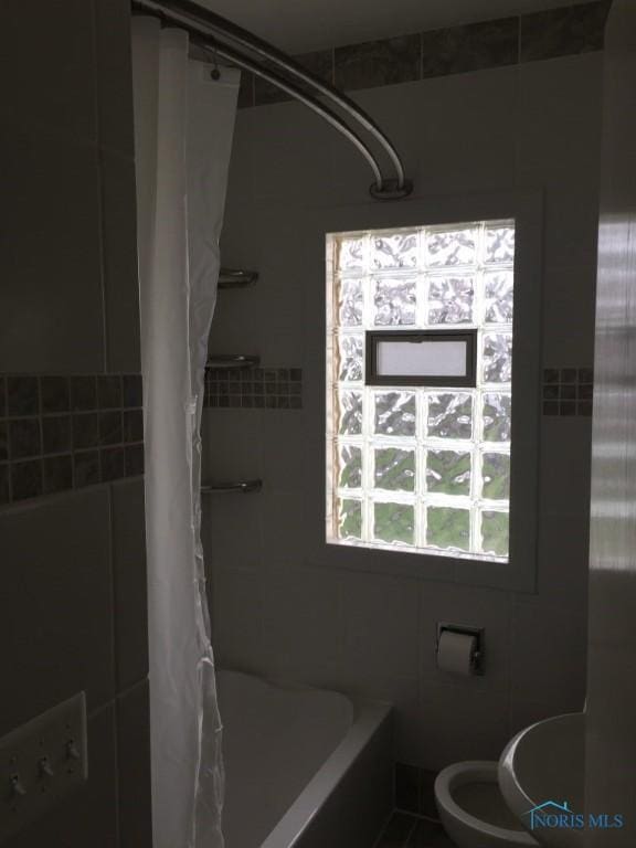 full bathroom featuring sink, tile walls, shower / tub combo, and toilet