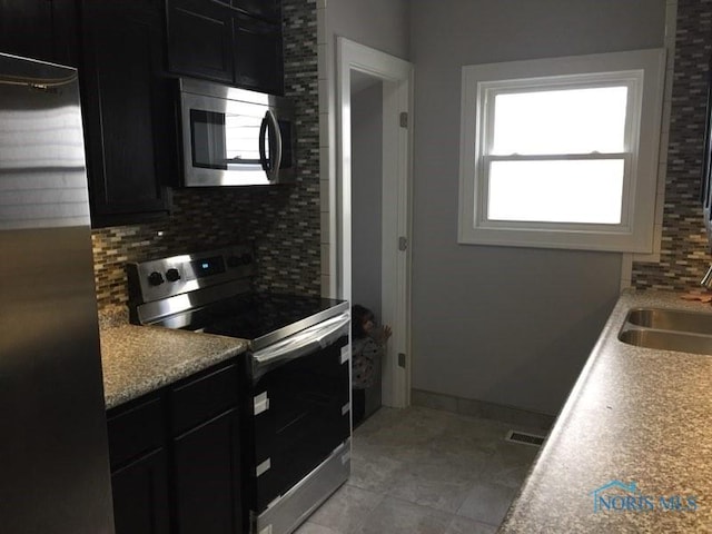 kitchen with appliances with stainless steel finishes, sink, and backsplash