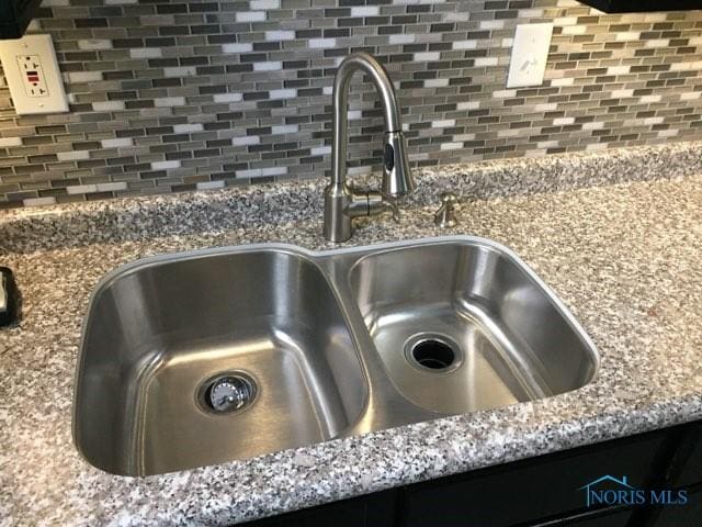 details with light stone counters, sink, and decorative backsplash