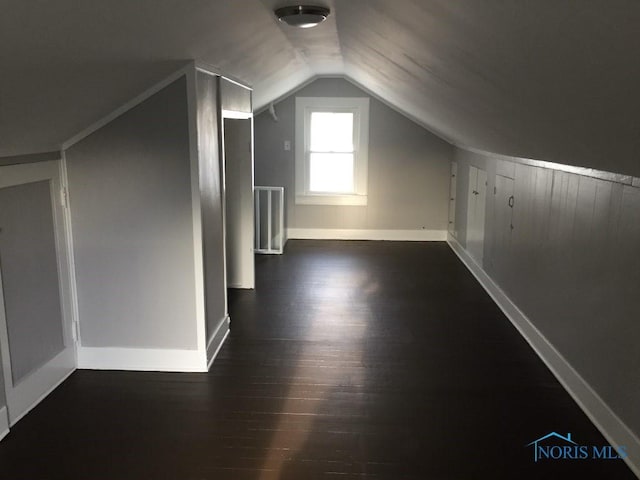 bonus room with lofted ceiling and dark hardwood / wood-style flooring