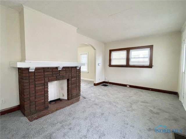 unfurnished living room featuring carpet and a brick fireplace