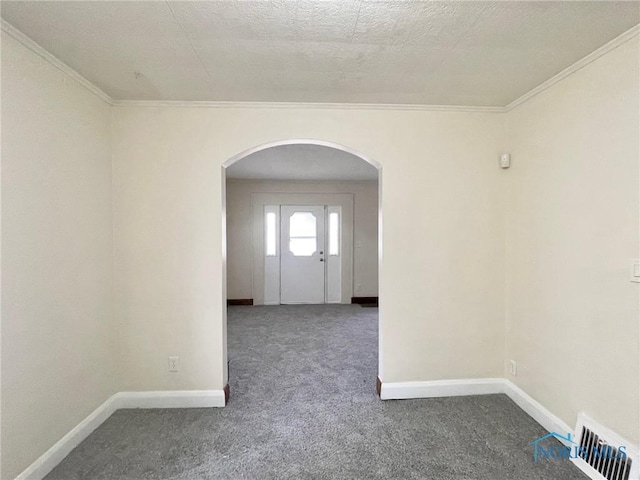 carpeted empty room with a textured ceiling and ornamental molding