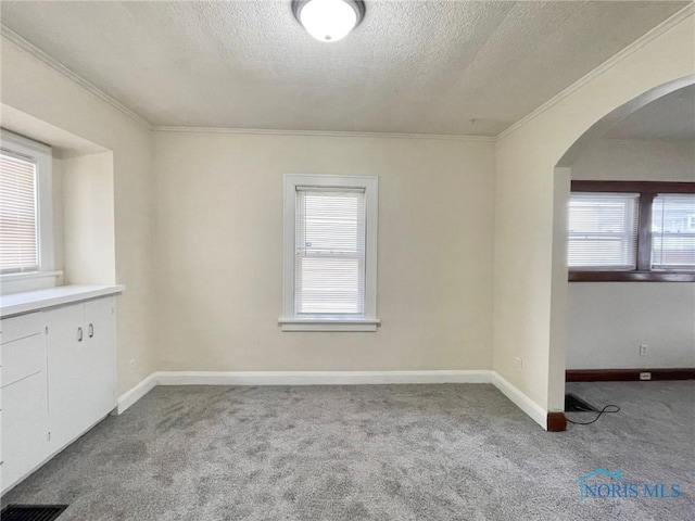 carpeted spare room featuring a textured ceiling and ornamental molding