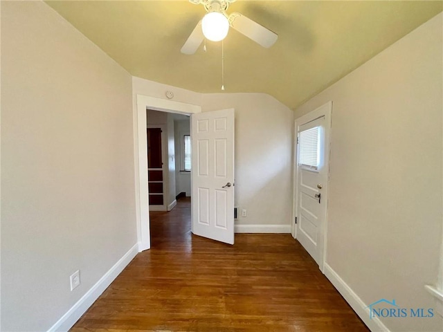 empty room with lofted ceiling, ceiling fan, and dark hardwood / wood-style flooring