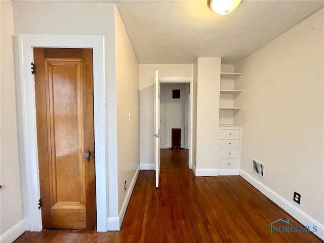 hall with built in shelves and dark hardwood / wood-style flooring