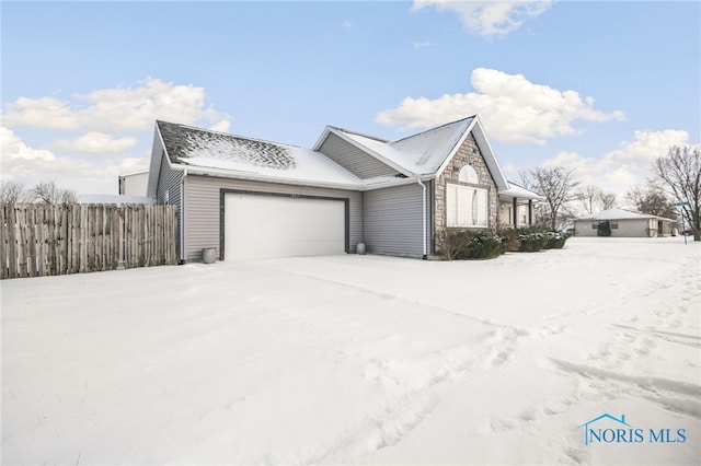 snow covered property with a garage