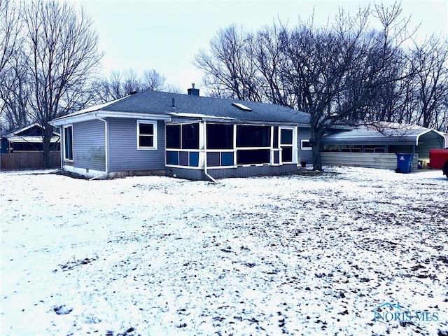 snow covered property featuring a sunroom