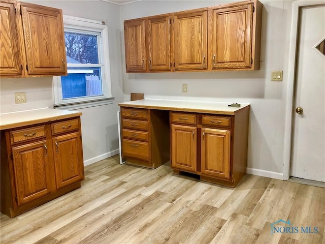 kitchen featuring built in desk and light wood-type flooring