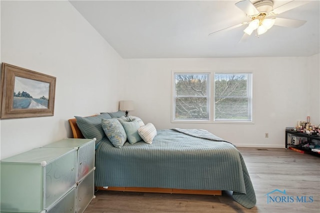 bedroom featuring wood-type flooring, lofted ceiling, and ceiling fan