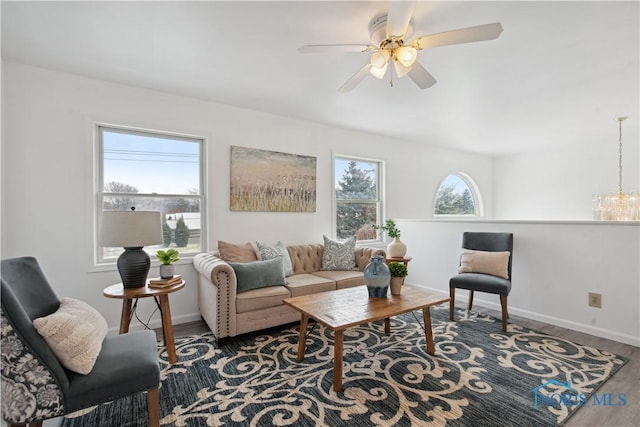 living room with hardwood / wood-style flooring, ceiling fan with notable chandelier, and a wealth of natural light