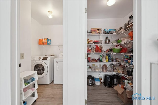 washroom with hardwood / wood-style floors and separate washer and dryer