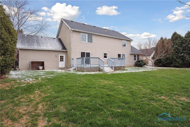 rear view of house with a deck and a lawn