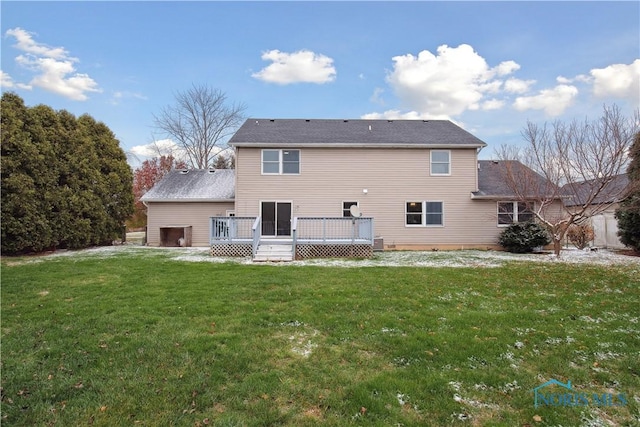 back of property with a deck and a lawn