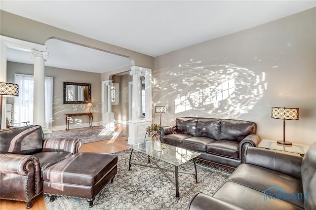 living room with decorative columns and wood-type flooring