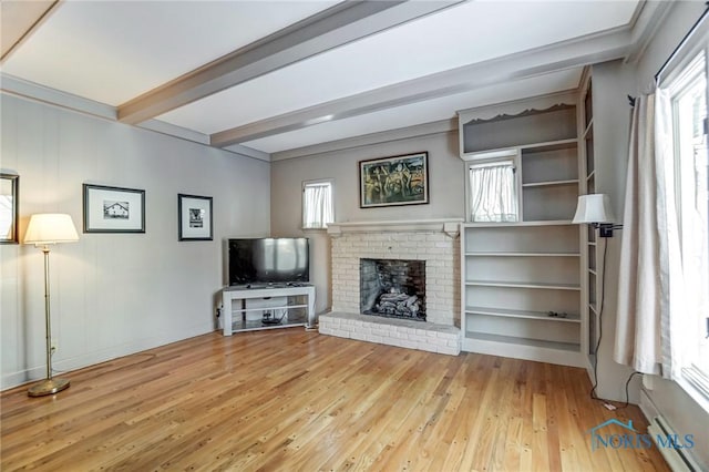 unfurnished living room featuring light wood-type flooring, beamed ceiling, and a brick fireplace