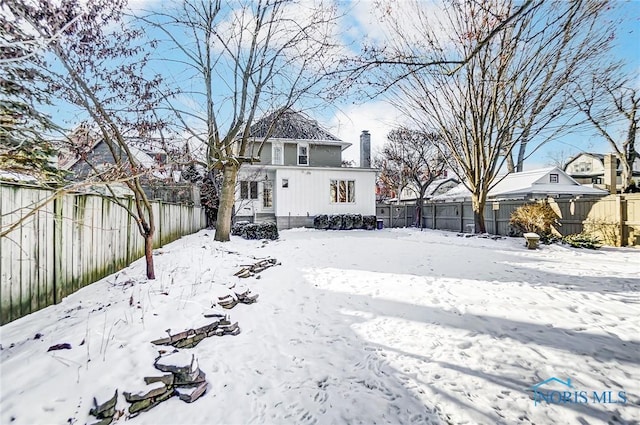 view of snow covered back of property