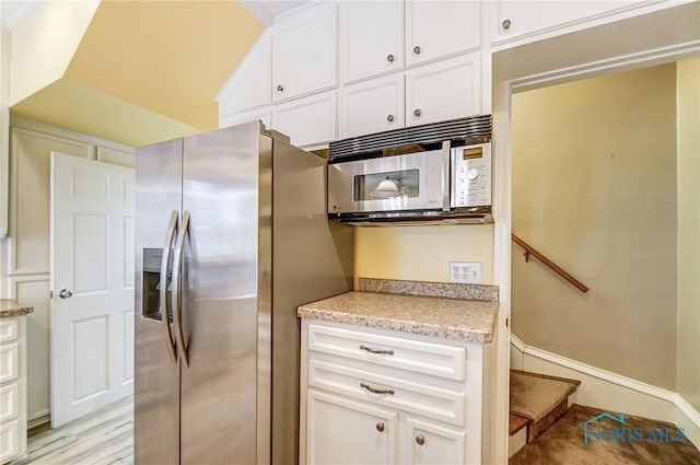 kitchen featuring white cabinets, light hardwood / wood-style flooring, and stainless steel appliances