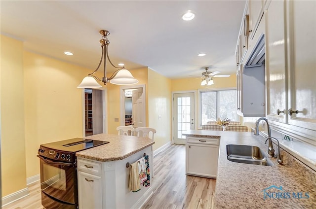 kitchen with decorative light fixtures, sink, white cabinets, and black range with electric cooktop