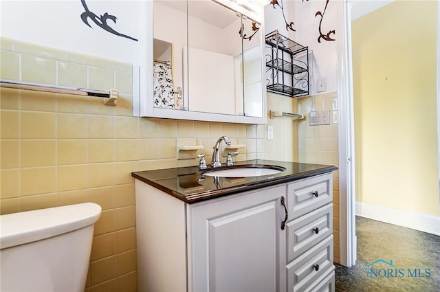 bathroom with toilet, tile walls, and vanity