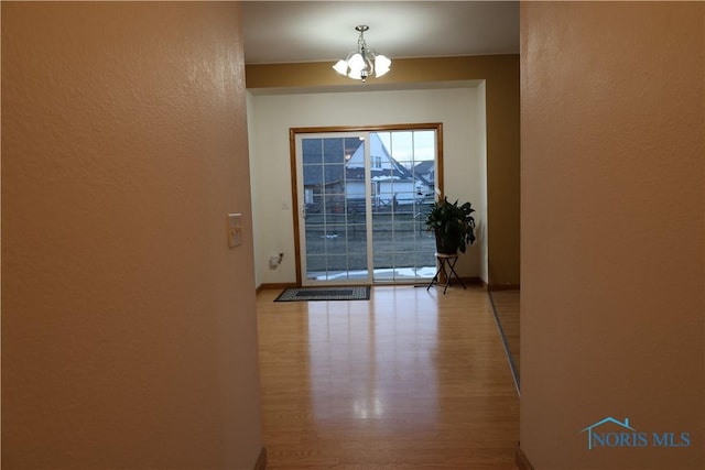 entryway featuring hardwood / wood-style flooring and an inviting chandelier