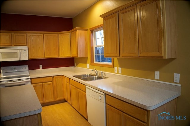 kitchen with sink, white appliances, and light hardwood / wood-style floors