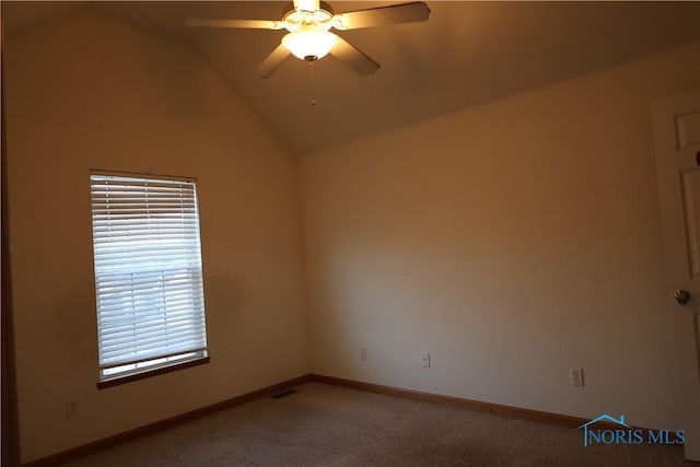 carpeted spare room featuring ceiling fan and vaulted ceiling