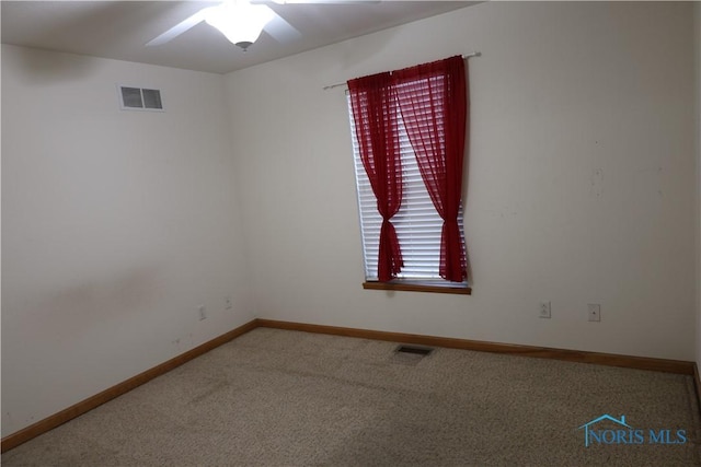 carpeted spare room featuring ceiling fan