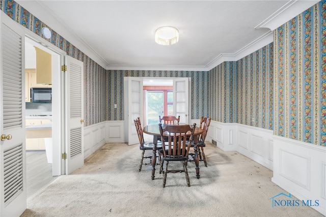 carpeted dining area with crown molding