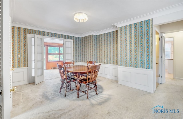 carpeted dining space with crown molding